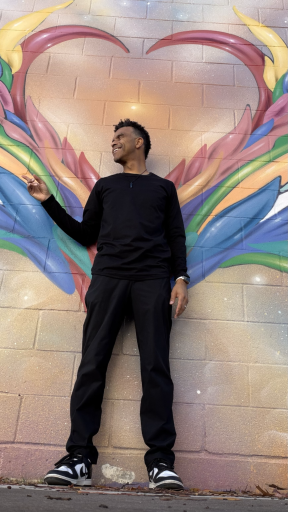 Budget Bill in front of a colorful rainbow mural